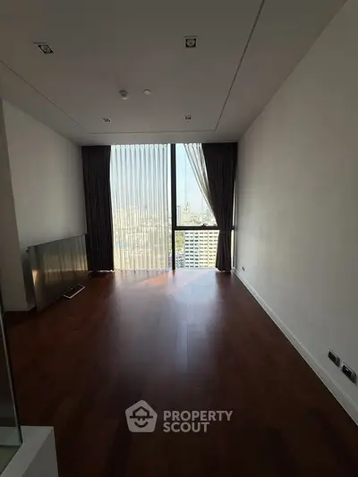 Spacious empty room with large window and city view, perfect for customization.