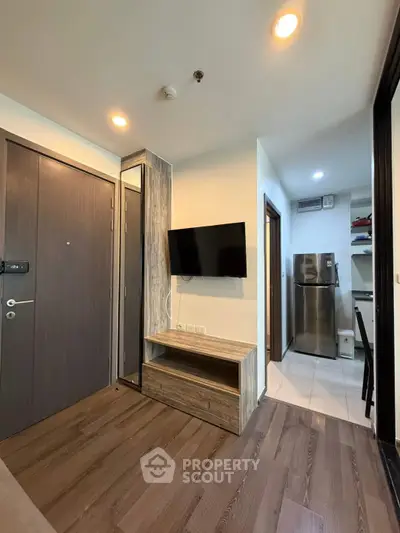 Modern apartment interior with wooden flooring and wall-mounted TV