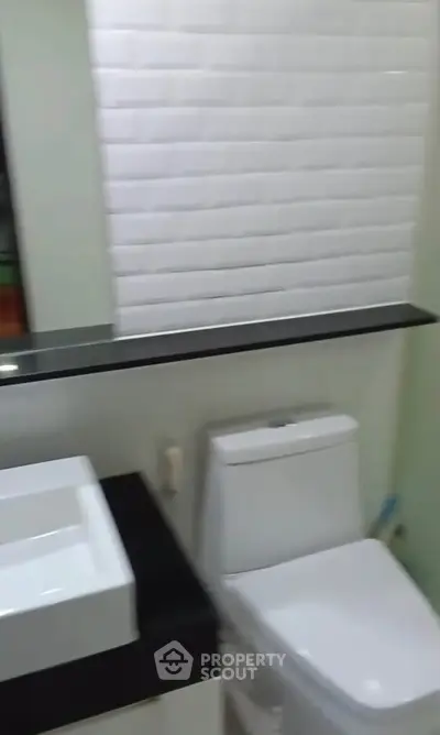 Modern bathroom with sleek white fixtures and stylish black countertop