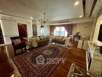 Luxurious living room with elegant chandelier and plush seating in a spacious apartment.
