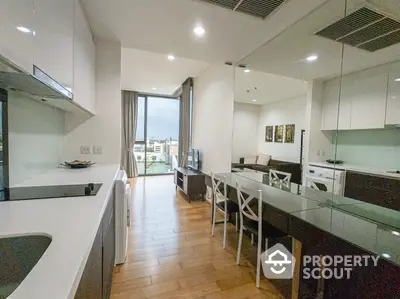 Modern open-layout kitchen and living area with sleek design and city view.