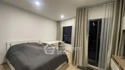 Modern bedroom with cozy bed and balcony access in urban apartment