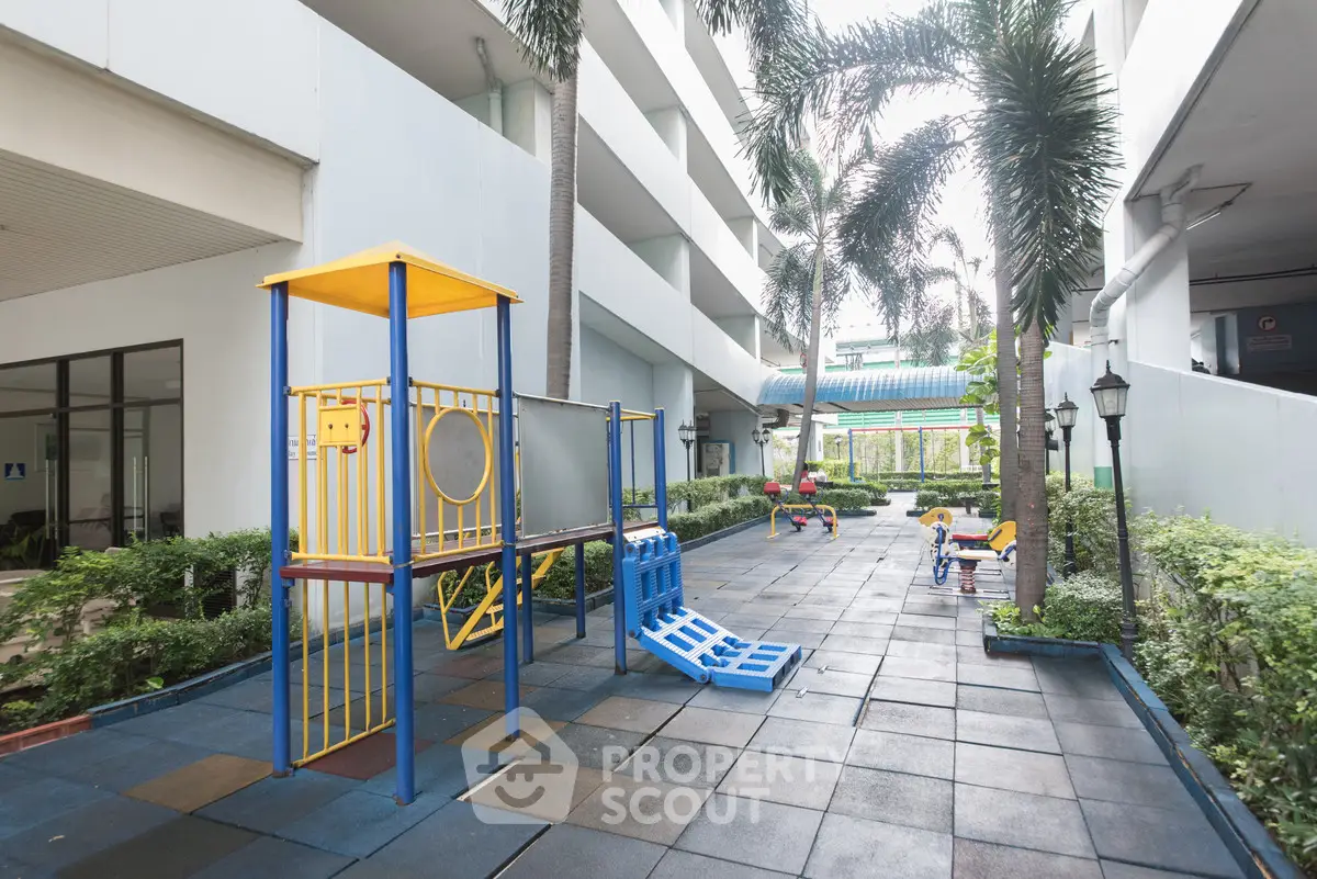 Modern apartment complex with outdoor playground and lush greenery, perfect for families seeking urban living with amenities.