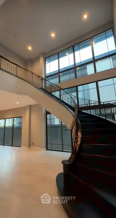 Luxurious modern staircase with elegant railing in spacious open-concept home interior.
