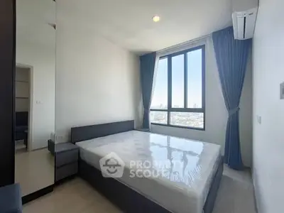 Modern bedroom with large window and city view, featuring sleek furniture and air conditioning.