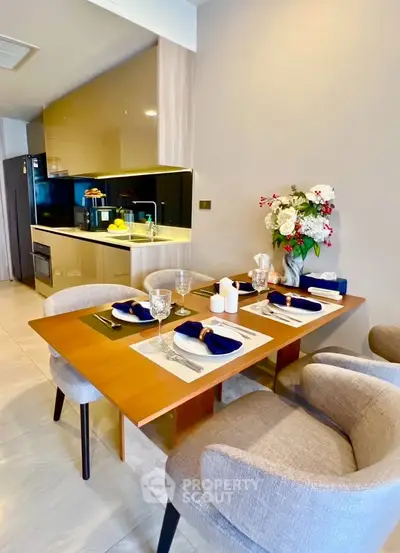 Modern kitchen with elegant dining setup and sleek appliances in a stylish apartment.