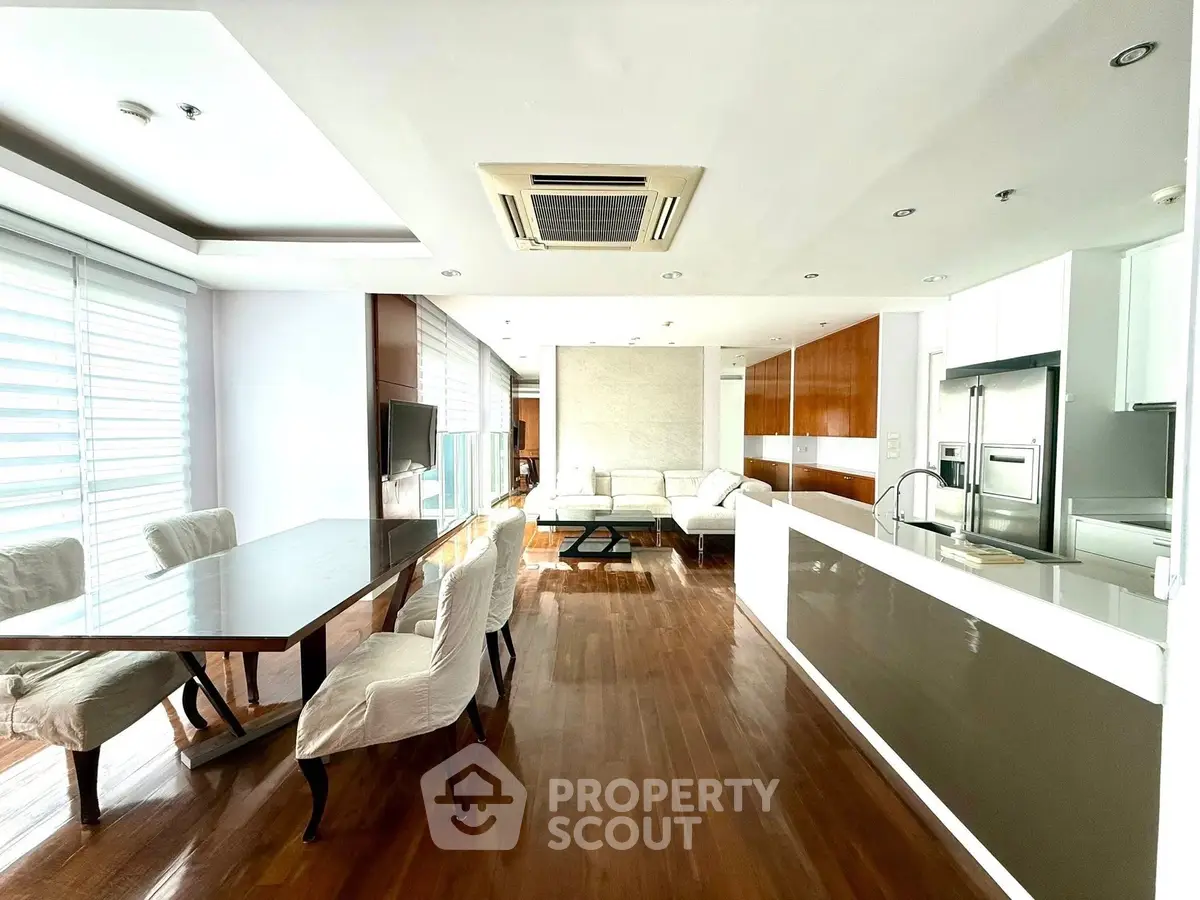 Spacious modern living and dining area with sleek kitchen and wooden flooring