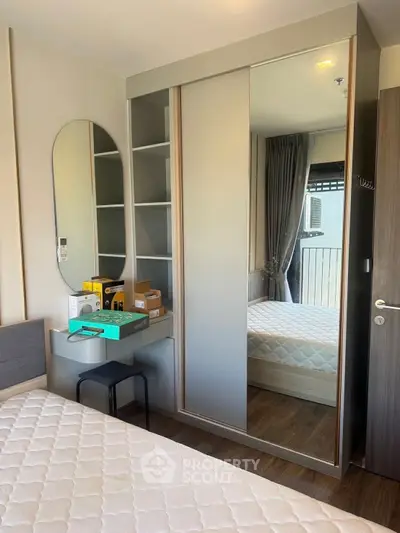 Modern bedroom with mirrored wardrobe and cozy decor in a stylish apartment.