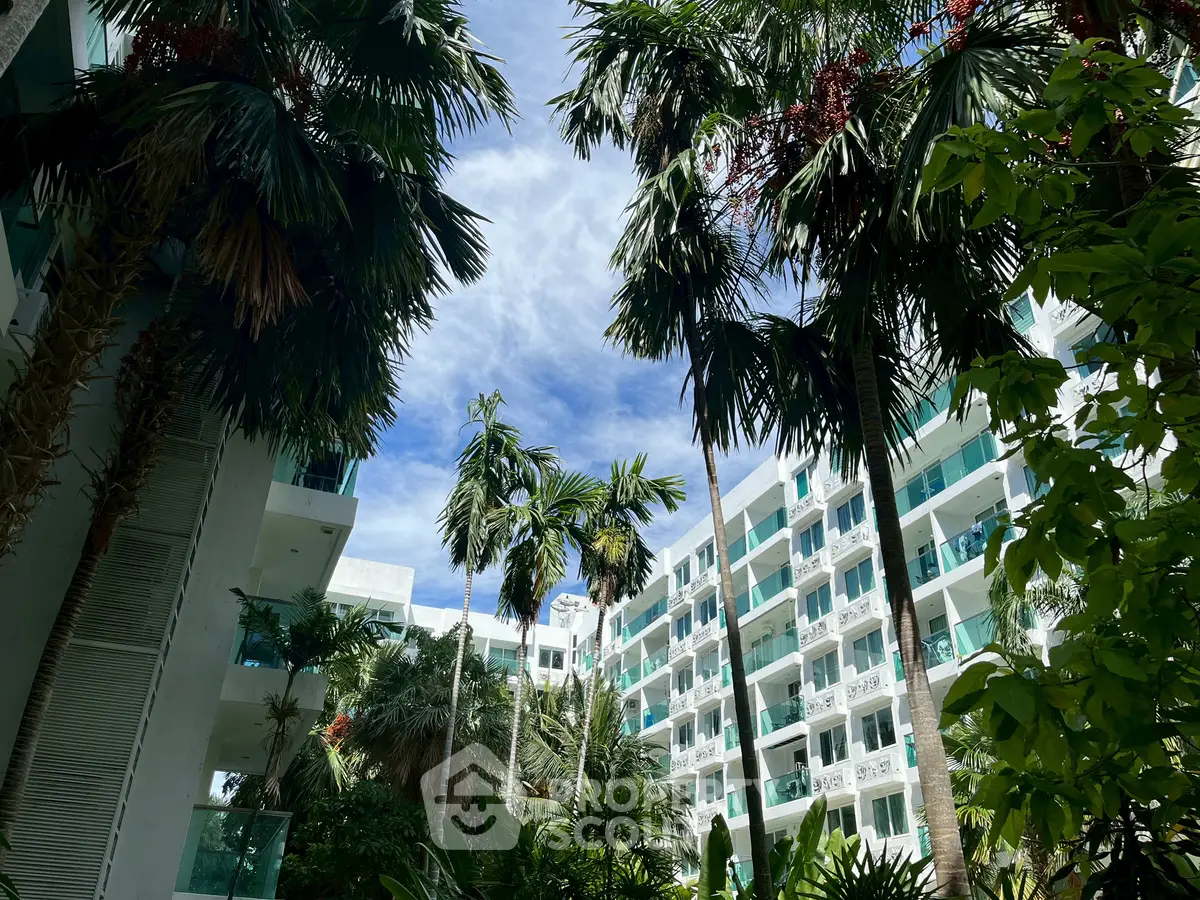 Luxurious tropical apartment complex with lush greenery and modern architecture.