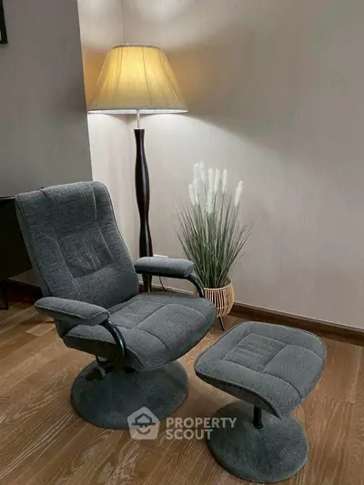 Cozy corner with plush armchair and ottoman, perfect for relaxation.