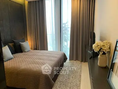 Luxurious bedroom with elegant decor and large window offering natural light.