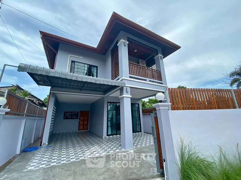 Modern two-story house with spacious driveway and stylish balcony.