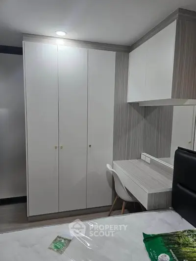 Modern bedroom with sleek wardrobe and compact study area, perfect for urban living.