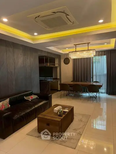 Luxurious living room with modern decor, elegant chandelier, and open dining area, perfect for stylish living.