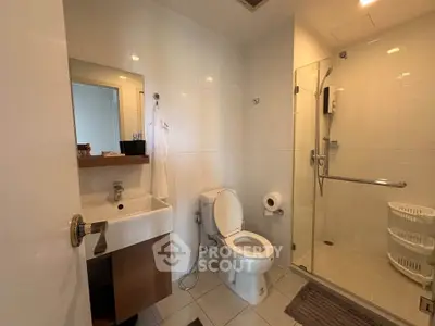 Modern bathroom with glass shower and sleek fixtures in a contemporary home.