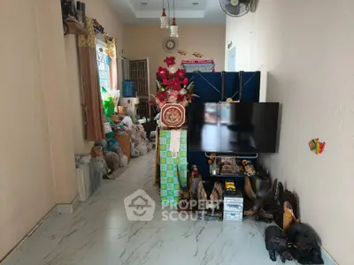 Cozy living room with TV, decorative items, and marble flooring