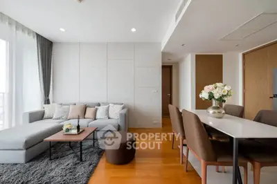 Modern living room with stylish decor and dining area, featuring a cozy sofa and elegant dining table.
