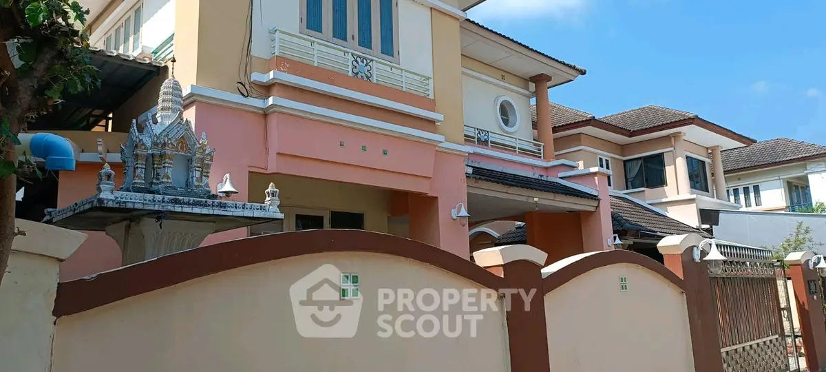 Charming two-story house with unique architectural design and gated entrance in a serene neighborhood.