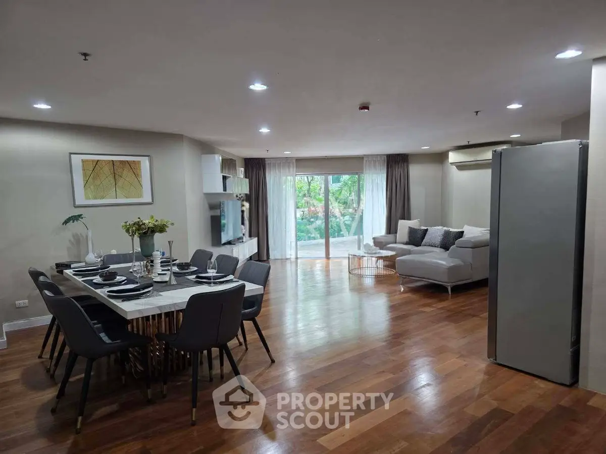 Spacious modern living room with elegant dining area and large windows offering garden views.
