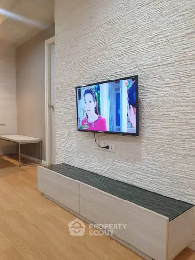 Modern living room with mounted TV and stylish wood flooring