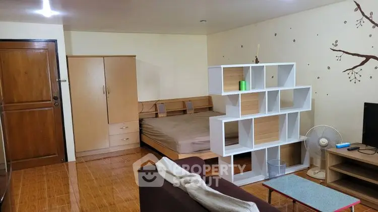 Cozy studio apartment with modern shelving and wooden flooring