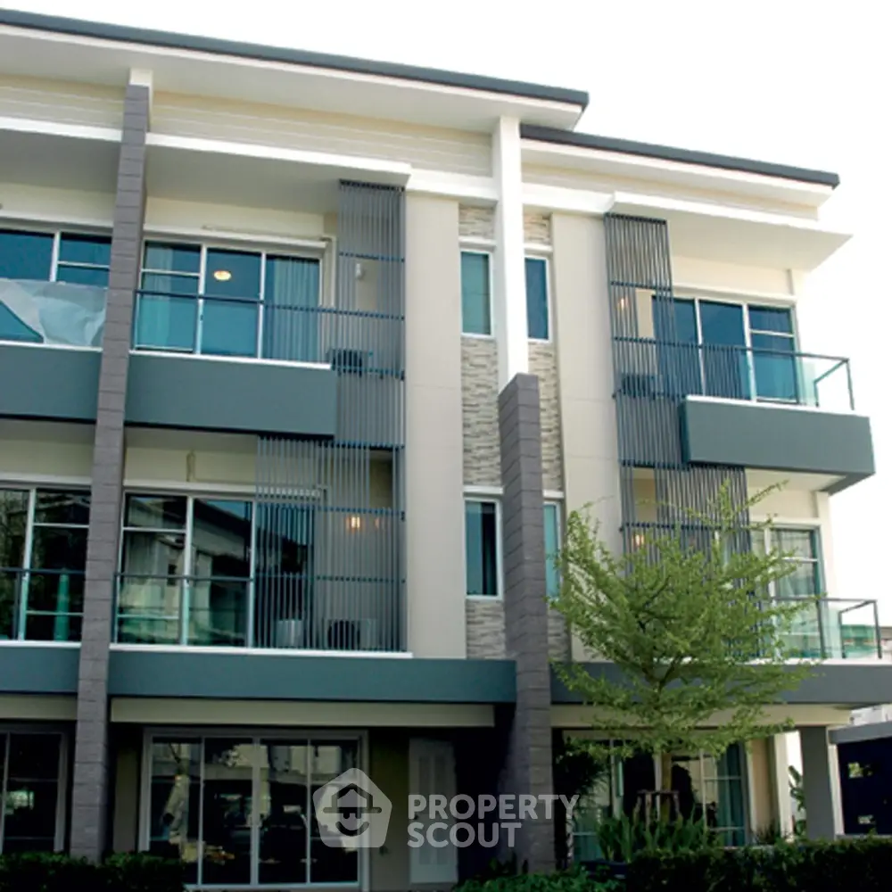 Modern multi-story building with sleek design and large windows in a suburban setting.