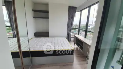 Modern bedroom with large windows and city view, featuring a minimalist design and ample natural light.