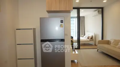 Modern apartment interior with open layout, featuring a sleek kitchen and cozy living area.