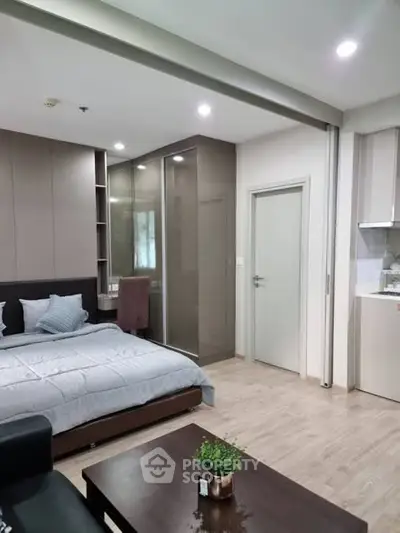 Modern studio apartment with cozy bedroom and compact kitchen