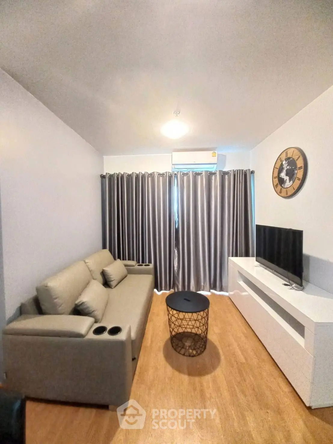 Modern living room with cozy sofa, sleek TV stand, and elegant curtains in a stylish apartment.