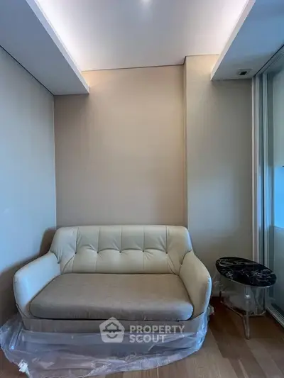 Modern living room with elegant beige sofa and stylish side table, perfect for cozy relaxation.