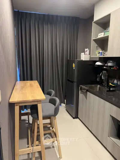 Modern kitchen with sleek design, featuring a compact dining area and stylish appliances.