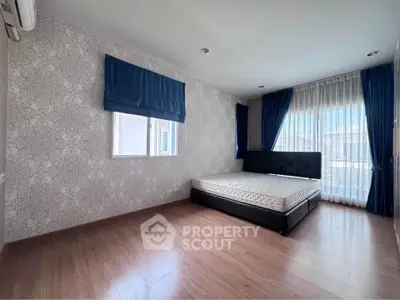 Spacious bedroom with elegant decor and large windows for natural light