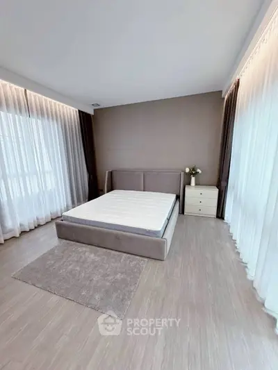 Spacious modern bedroom with large windows and elegant decor