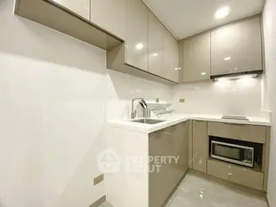 Modern kitchen with sleek cabinetry and built-in appliances in a compact layout.