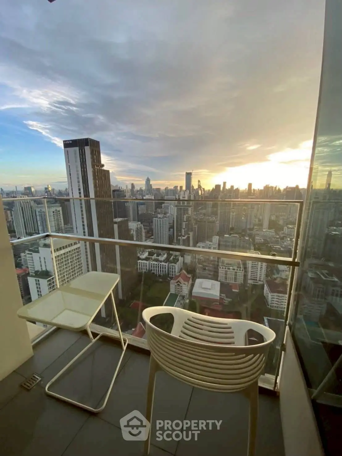 Stunning cityscape view from modern high-rise balcony at sunset