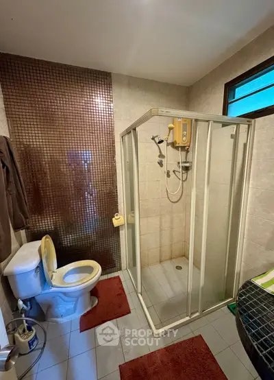 Cozy bathroom with shower enclosure and modern fixtures, perfect for relaxation.