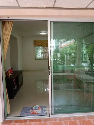 Spacious living area with sliding glass doors opening to a serene outdoor view, perfect for relaxation.