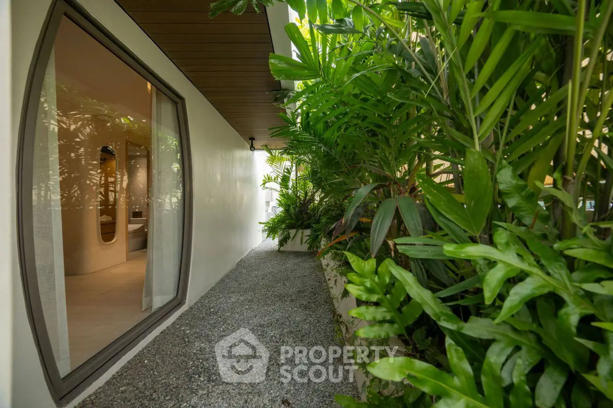 Modern home exterior with lush garden and large window view