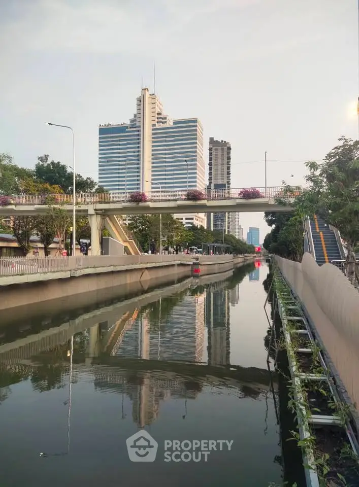 Stunning cityscape view with modern high-rise buildings and serene canal reflection.