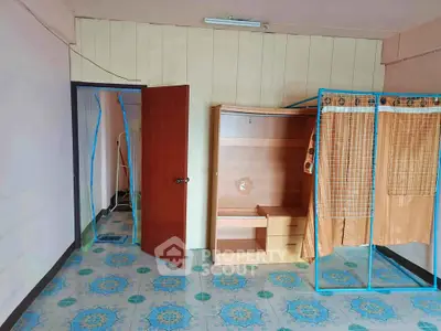 Modest room with basic furnishings and tiled floor, ideal for budget-conscious renters.