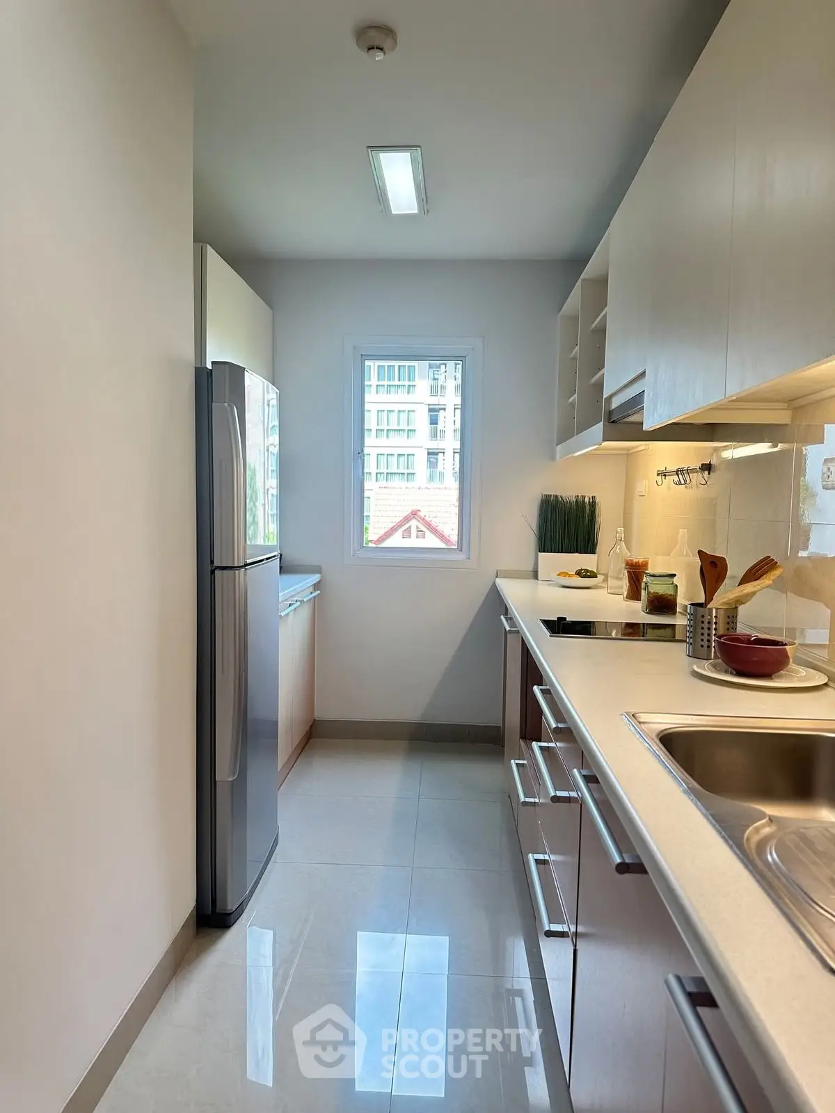 Modern kitchen with sleek cabinets, stainless steel appliances, and a bright window view.
