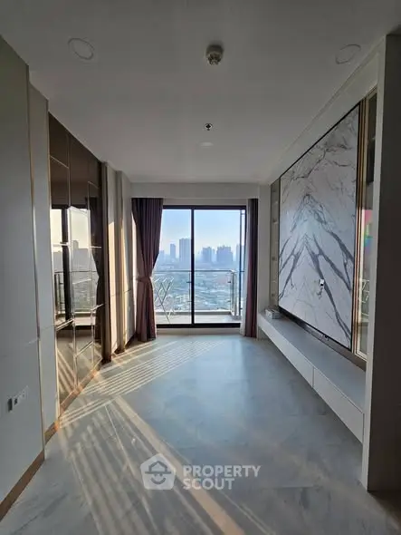 Spacious modern living room with large windows offering stunning city views and elegant marble accents.