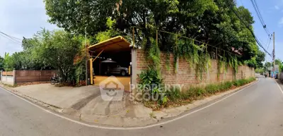 Charming corner property with lush greenery and spacious driveway in serene neighborhood.