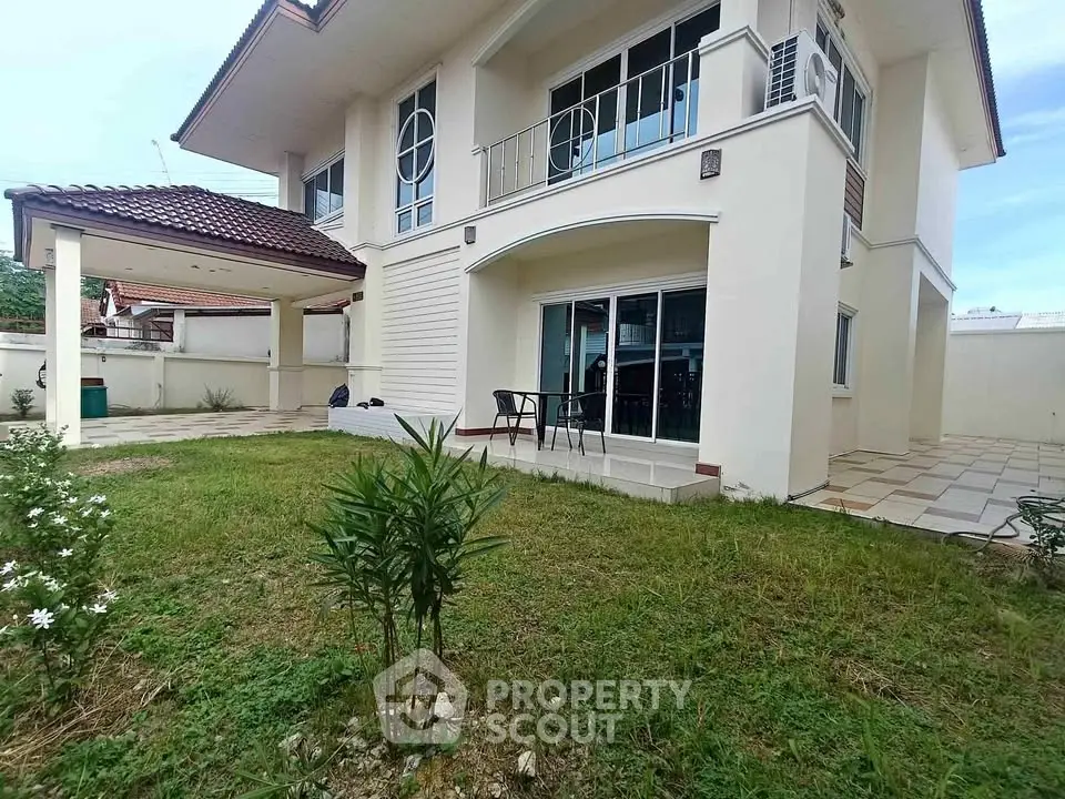 Charming two-story house with spacious garden and covered patio, perfect for family living.