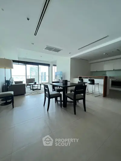Spacious modern living room with open kitchen and city view, perfect for urban living.
