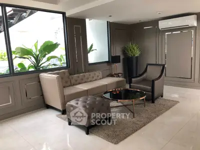 Elegant living room with modern furniture and large windows, perfect for relaxation and entertaining.