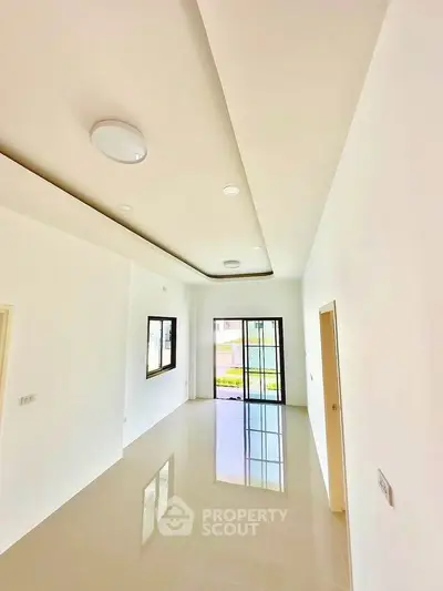 Spacious modern living room with large windows and glossy tiled floors