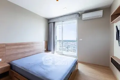 Modern bedroom with balcony view and air conditioning in a stylish apartment.