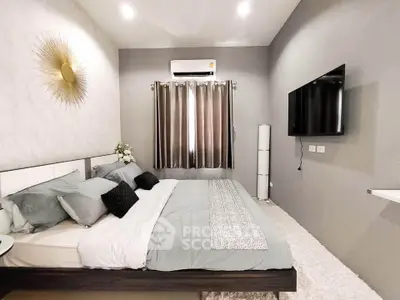 Modern bedroom with stylish decor and wall-mounted TV, featuring cozy bedding and ambient lighting.